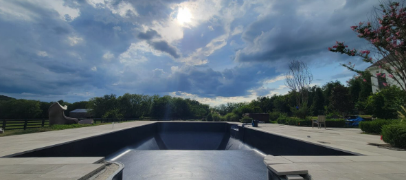 Custom dark-finish inground gunite pool with travertine decking in Middle Tennessee